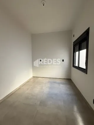 Interior de um cômodo com paredes brancas e piso claro.