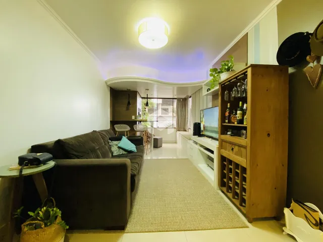 Sala de estar com sofá e móveis de madeira em um imóvel no Brasil.