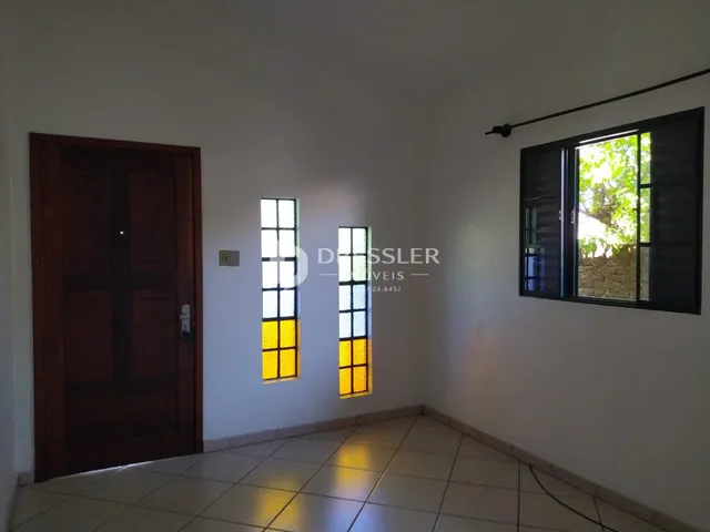 Vista interna de uma sala com portas e janelas em um imóvel.