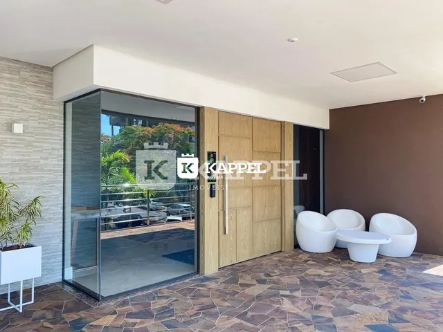Foto da sala de estar com portas de vidro que dão acesso ao exterior.