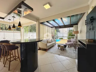 Sala de estar com vista para o exterior e teto de vidro.