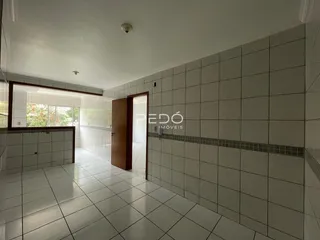 Hall de corredor com piso e parede revestidos de cerâmica branca.