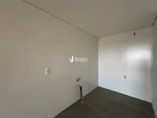 Interior de um ambiente com paredes brancas e piso cinza.
