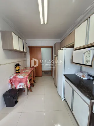 Vista interna de um corredor com armários e portas de madeira.