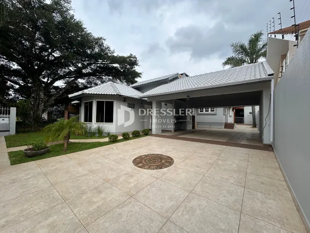 Vista da fachada de uma residência em Lajeado, Brasil, com área externa pavimentada.