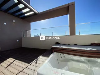 Foto da varanda com deck de madeira e banheira de hidromassagem.