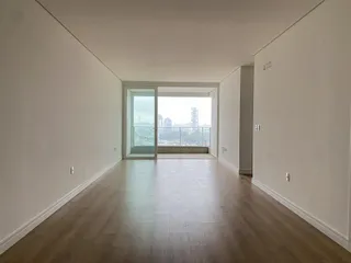 Hall de corredor com piso de madeira e vista para a cidade.