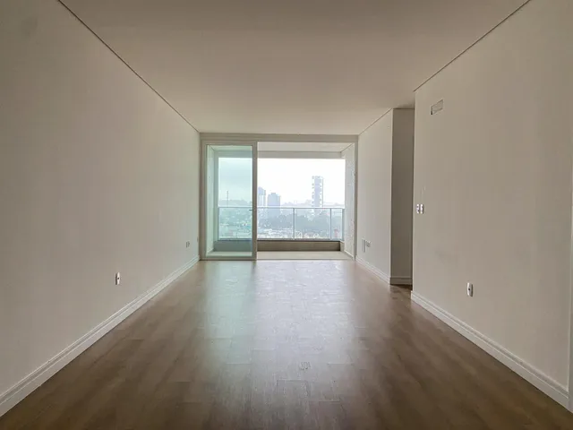 Hall de corredor com piso de madeira e vista para a cidade.