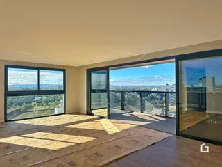 A sala de estar possui grandes janelas com vista para a paisagem.