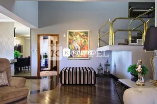 Sala de estar com piso de madeira e quadro na parede.