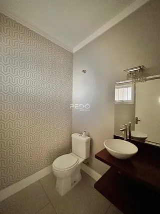 Foto de um banheiro interno com revestimento de parede e louças sanitárias.