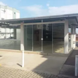 Fachada de um imóvel residencial com estrutura de vidro e cobertura.