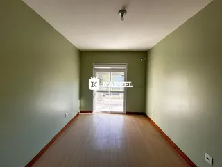 Hall de corredor com piso de madeira e porta de vidro que dá acesso ao quintal.