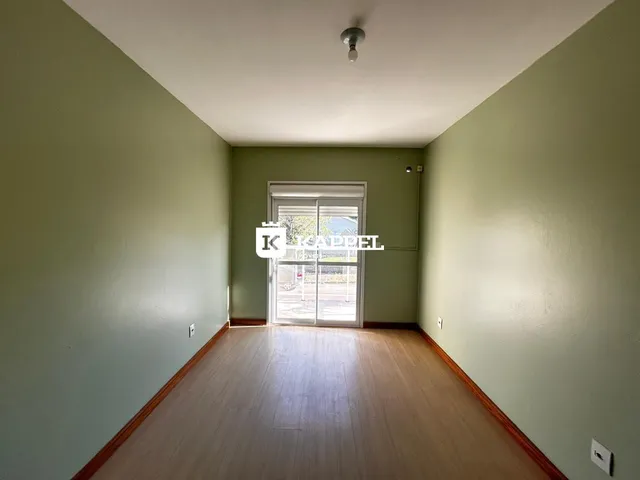 Hall de corredor com piso de madeira e porta de vidro que dá acesso ao quintal.