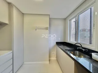 Foto de uma cozinha moderna com bancada escura e piso claro.