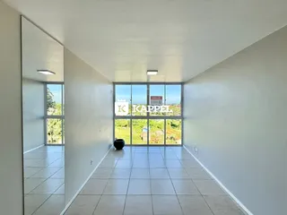 Hall de entrada com piso de cerâmica e grande janela com vista externa.