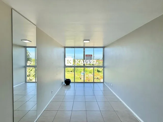 Hall de entrada com piso de cerâmica e grande janela com vista externa.