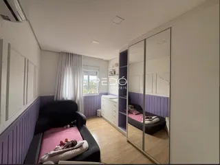 Quarto com armários embutidos e piso de madeira em um imóvel no Brasil.