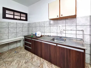 Foto de uma cozinha com armários de madeira escura e revestimento de azulejos claros.