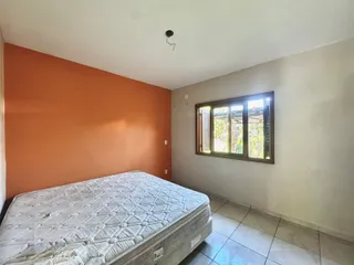 Quarto com cama grande e parede em tom terracota.