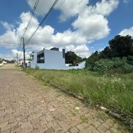 Fachada de uma casa moderna branca em Lajeado, Brasil, com paisagismo ao redor.