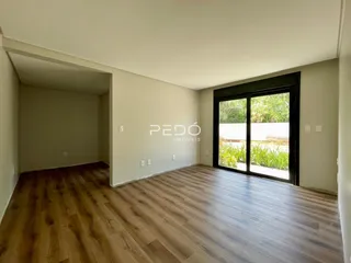 Sala de estar com piso de madeira e porta de vidro.