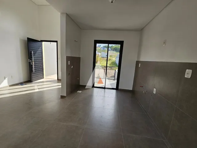 Hall de entrada com piso de cerâmica e portas de madeira.