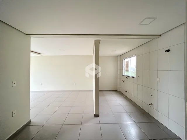 Interior de uma sala com piso de cerâmica e paredes brancas.