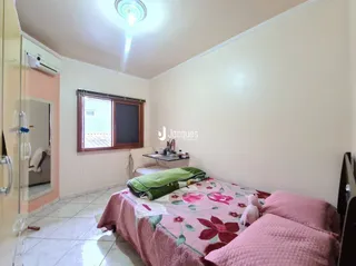 Quarto com cama e janela em uma residência.