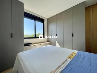 Quarto com cama grande e armários em tons neutros.