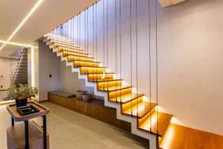 Hall de entrada com escadaria e revestimento de madeira em um apartamento.