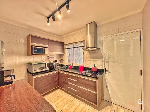 Foto de uma cozinha com armários de madeira e revestimento cerâmico.
