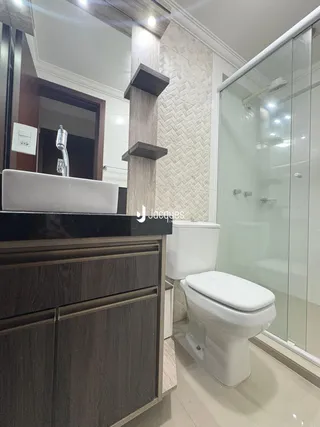 Foto de um banheiro moderno com box de vidro e louças sanitárias.