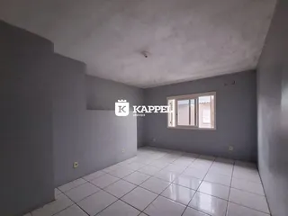 Uma sala de estar com piso de cerâmica branca e paredes cinza claro.