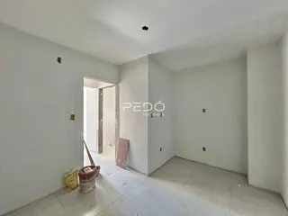 Vista interna de um ambiente com paredes brancas e piso claro.
