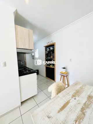 Cozinha com armários superiores de madeira e piso de cerâmica.