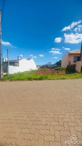 Vista externa de uma propriedade com muro branco e céu azul.