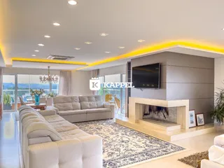 Sala de estar moderna com sofá grande e lareira em ambiente claro.
