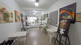 Interior de um corredor longo com paredes brancas e arte nas paredes.