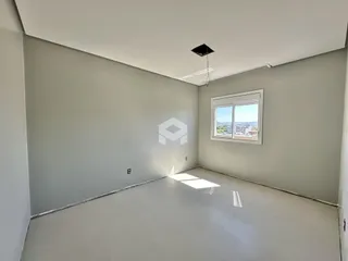 Vista interna de um cômodo vazio com paredes brancas e piso claro.