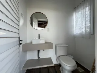 Foto de um banheiro interno com bancada e vaso sanitário.