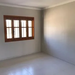 Interior de um cômodo com janela de madeira clara.