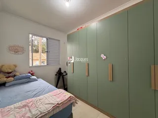 Quarto com cama e armários em tom verde.
