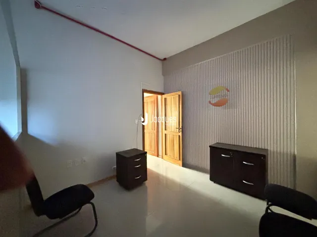 Sala de estar com paredes claras e portas de madeira.