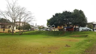 Campo gramado com árvores ao fundo em uma propriedade.