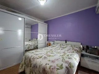 Quarto com paredes roxas e armários brancos em um imóvel no Brasil.