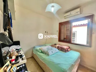 Este é um quarto com cama e janela de madeira.