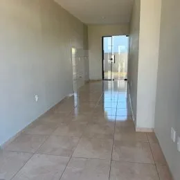 Corredor interno com piso de cerâmica e paredes claras.