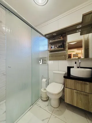 Foto de um banheiro moderno com box de vidro e bancada de madeira.