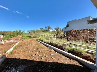 Vista de terra e vegetação em uma área de construção no Brasil.